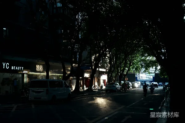 高清摄影 黑暗的城市街道，有汽车和树木。