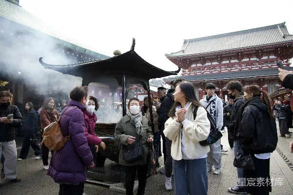 高清摄影 人们聚集在寺庙附近，缭绕的香烟升起。