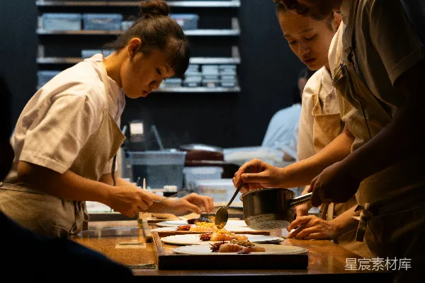 高清摄影 一群人围在厨房周围准备食物。