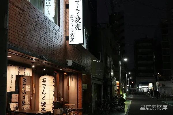 高清摄影 一条昏暗的街道，街道上有一栋建筑物，建筑物上有亚洲文字。