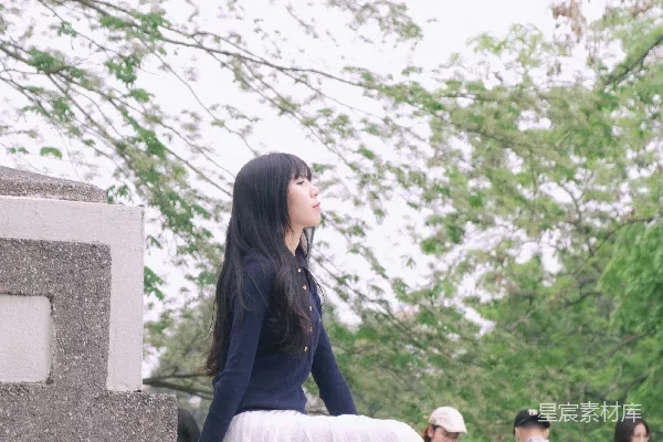 高清摄影 一位女士坐在石墙上。