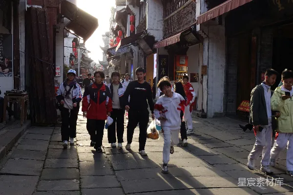 高清摄影 人们沿着两旁是建筑物的石板路行走。