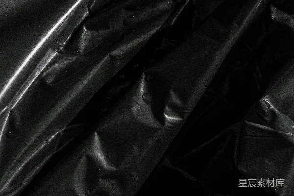 高清摄影 闪闪发光的黑色皱巴巴的塑料上沾有水滴。