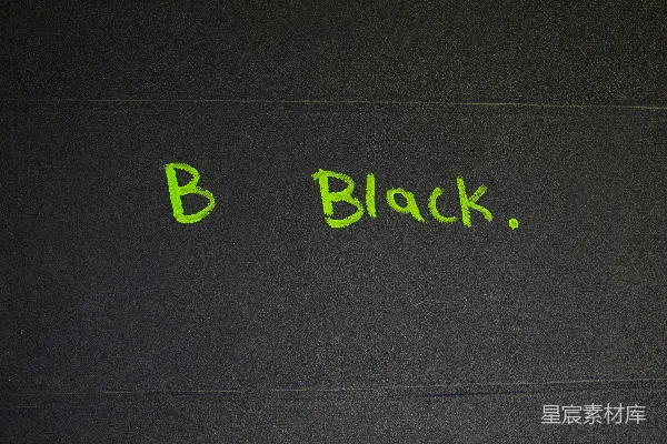 高清摄影 绿色字母拼写“b black.”在深色背景上。
