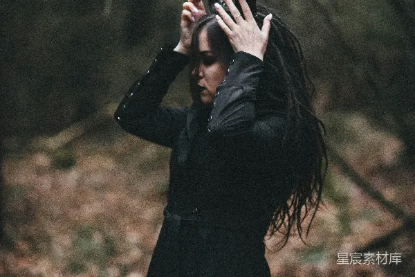 高清摄影 一个穿着黑色连衣裙的女人把双手举到头顶。