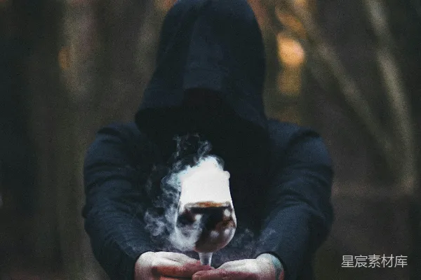 高清摄影 一个穿着斗篷夹克的人手里拿着一支香烟。