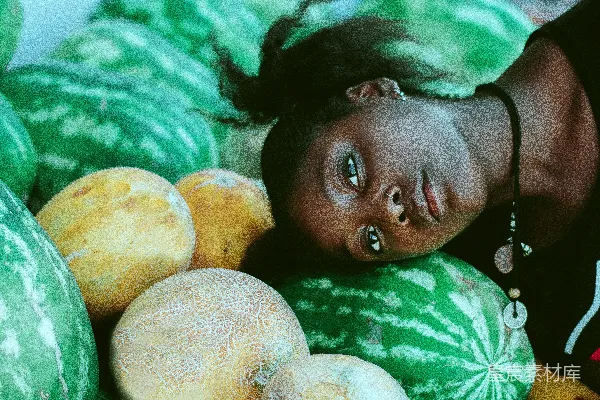 高清摄影 女人穿着黑白相间的衬衫，头靠在绿色的西瓜旁边，旁边还有甜瓜。