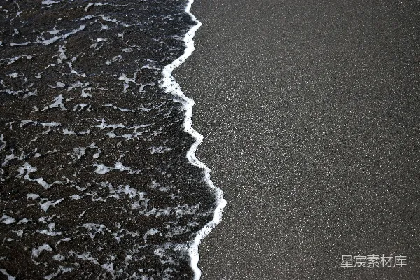 高清摄影 一个黑色沙滩，海浪正在涌来。