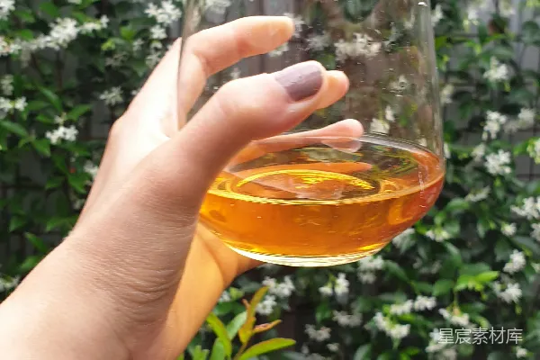 高清摄影 手里拿着一杯棕色液体的透明玻璃杯的人