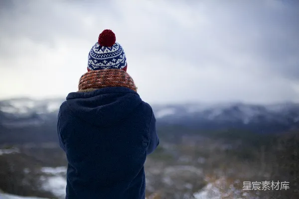 高清摄影 穿着蓝色连帽衫的人面对着山脉。