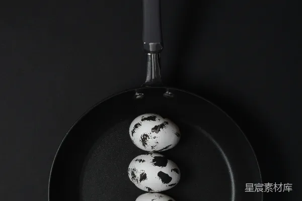 高清摄影 四颗斑点鸡蛋在黑色的煎锅里。