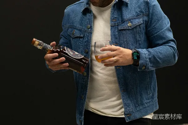 高清摄影 穿着蓝色牛仔夹克的男人手里拿着智能手机。