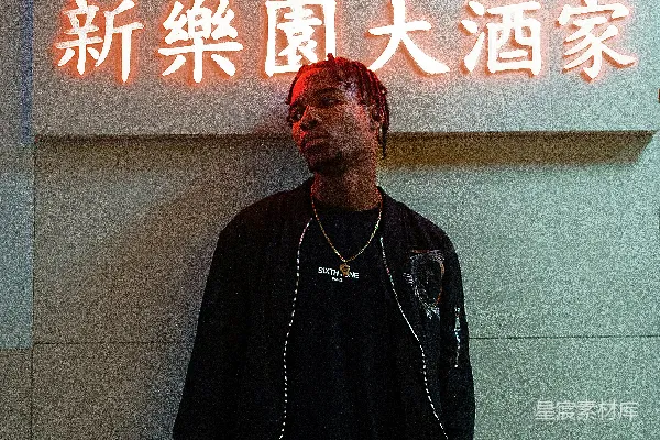 高清摄影 一个男人站在霓虹灯招牌前。