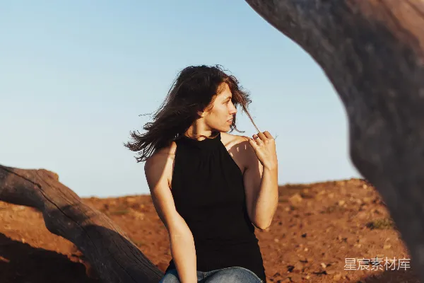 高清摄影 一个女人坐在树枝上抽烟。