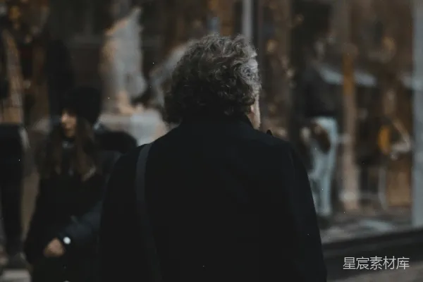 高清摄影 一个女人走过街边一家商店的店面。