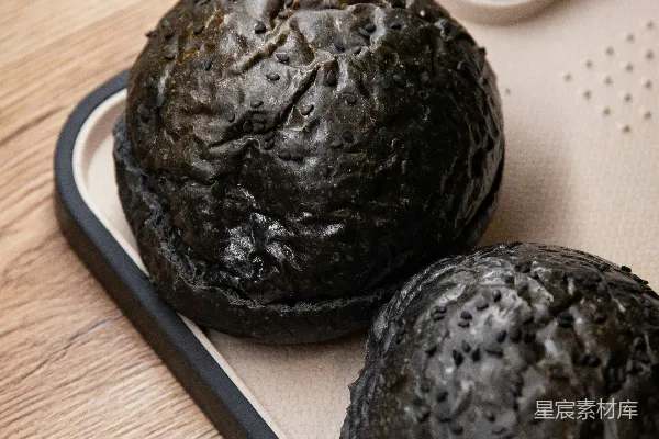 高清摄影 两个黑色的圆形果实放在白色桌垫上