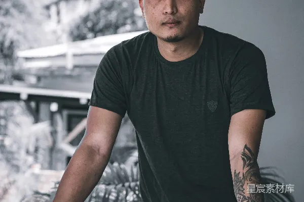 高清摄影 穿着黑色圆领T恤的男人站着并微笑。