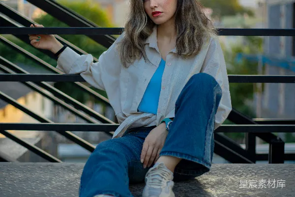 高清摄影 一个女人坐在金属栏杆的顶部