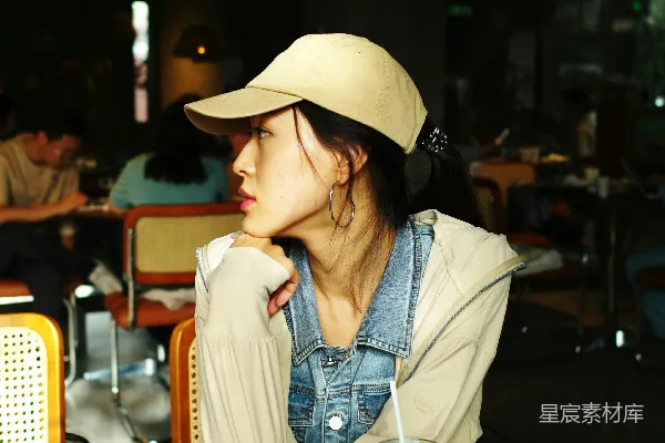 高清摄影 一位女士坐在桌子旁，面前有一杯饮料。