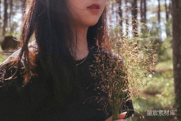 高清摄影 女人在白天拿着花靠近树木。