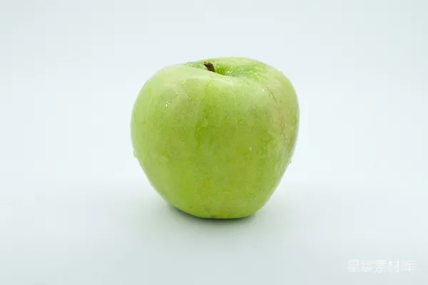 高清摄影 一个绿色的苹果放在白色桌子的上面。