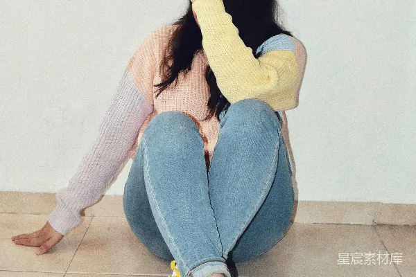 高清摄影 穿着粉红色毛衣和蓝色牛仔裤的女人坐在地上。