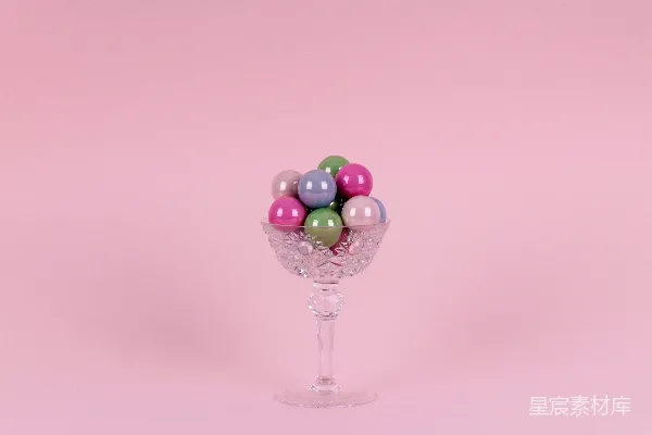 高清摄影 紫色和绿色的气球放在透明玻璃底座的碗上