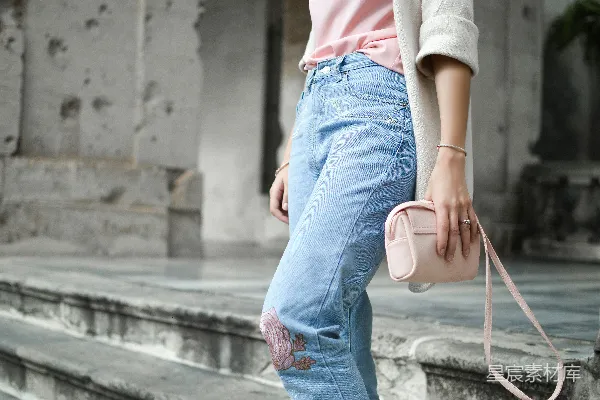 高清摄影 一名女性手持粉色皮革跨肩包走在楼梯上。
