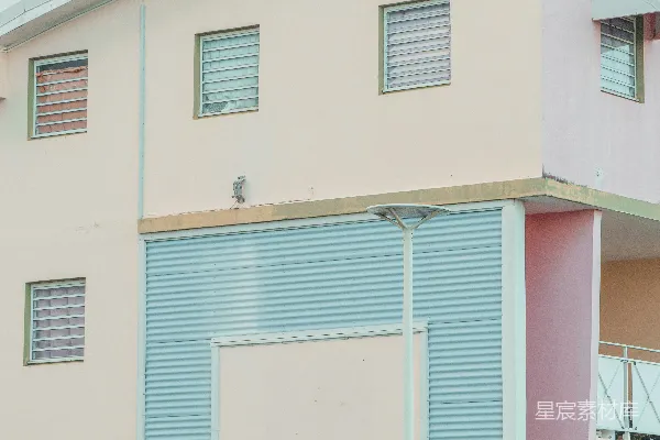 高清摄影 一座粉蓝相间的建筑紧邻着栅栏。