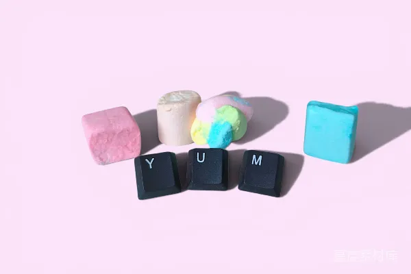 高清摄影 彩色棉花糖和“yum”键盘键在粉红色背景上。