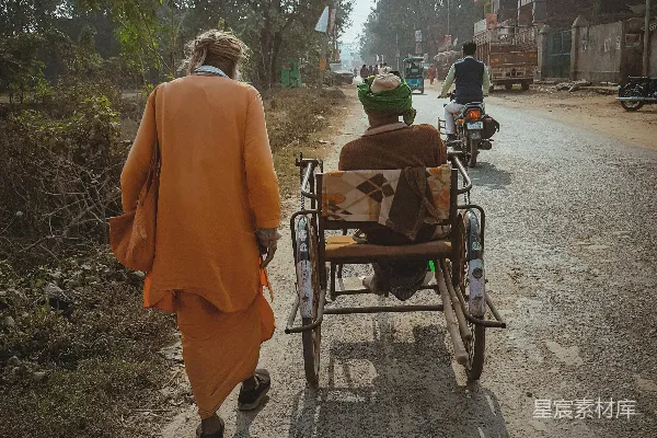 高清摄影 一个男人沿着一条土路走着，旁边有一只狗坐在车上。