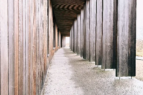 高清摄影 一排长条形的木杆靠在建筑物一侧