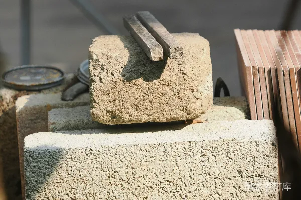 高清摄影 一叠建筑砖块，上面放着金属工具。