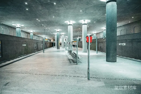 高清摄影 一座空旷的现代化混凝土地铁站台，柱子上亮着灯。