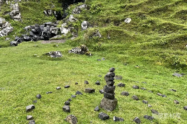 高清摄影 一个长满草的山坡，上面有岩石和树木。