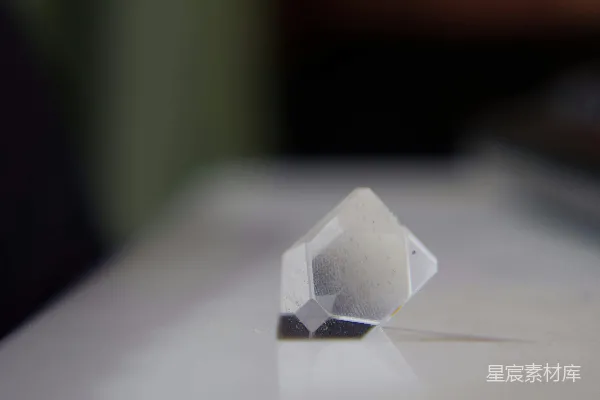 高清摄影 一块清晰的几何水晶放在白色表面上。