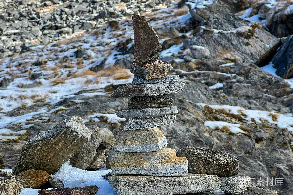高清摄影 一堆石头堆在雪覆盖的地面上。
