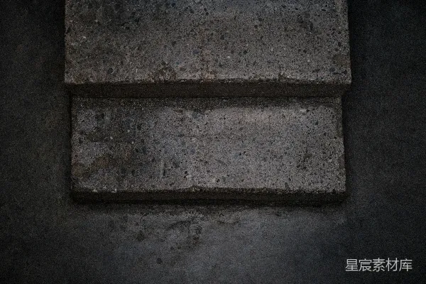 高清摄影 一块方形砖块坐落在水泥地板上。