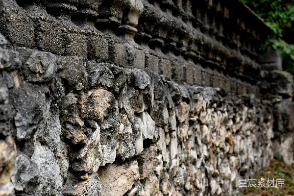 高清摄影 一座带有装饰雕刻和粗糙部分的老石墙。