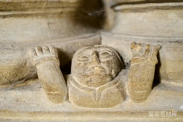 高清摄影 雕刻有双手放在两侧的脸部雕像