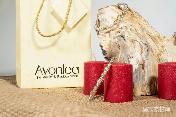 高清摄影 金色手镯挂在烛台和木制装饰旁边，旁边还有一个纸袋。