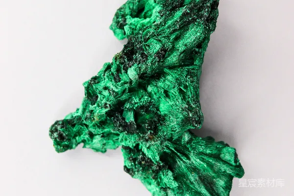 高清摄影 一块白色背景上的绿色铜矿矿物标本。