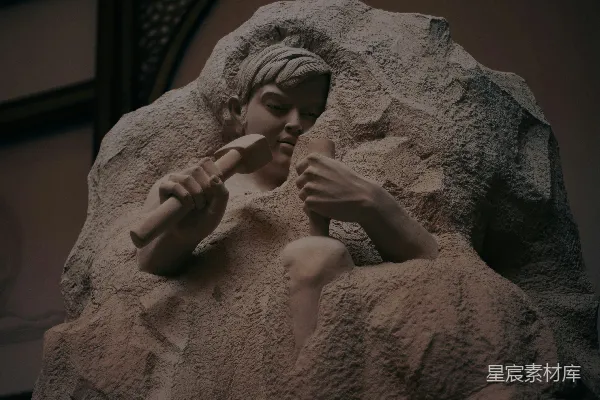 高清摄影 一个男人用锤子和凿子雕刻石头的雕塑。