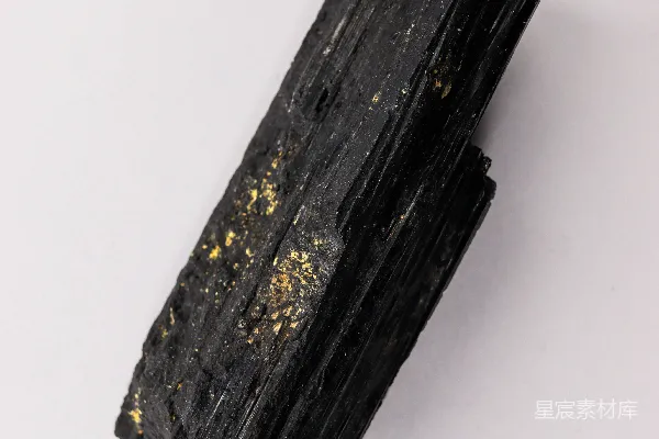 高清摄影 黑碧玺晶体，白色背景上有金色斑点。