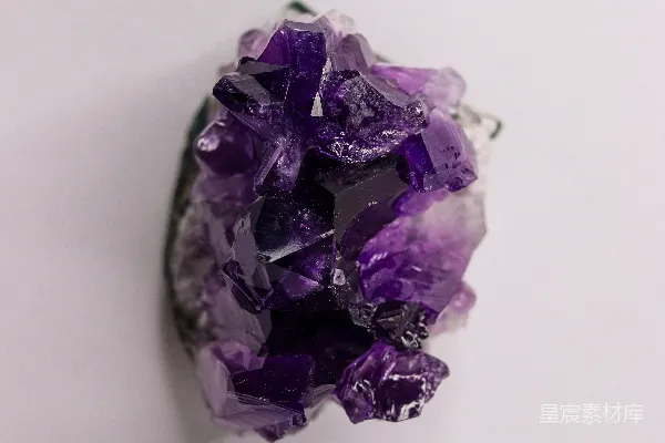 高清摄影 一块鲜艳的紫色紫晶水晶洞，背景为白色。