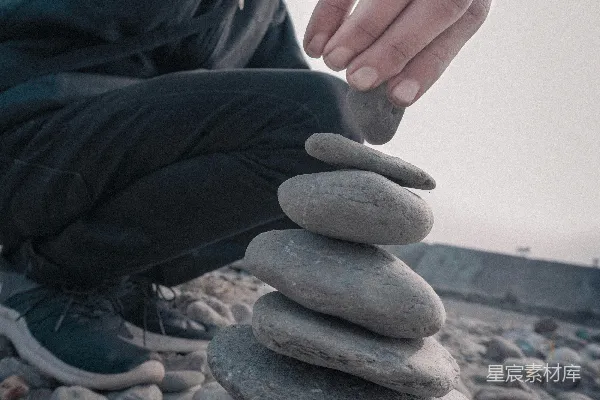 高清摄影 一个人把石头叠在彼此上面