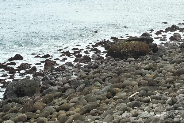 高清摄影 一个岩石海滩，海浪轻轻拍打着海岸。