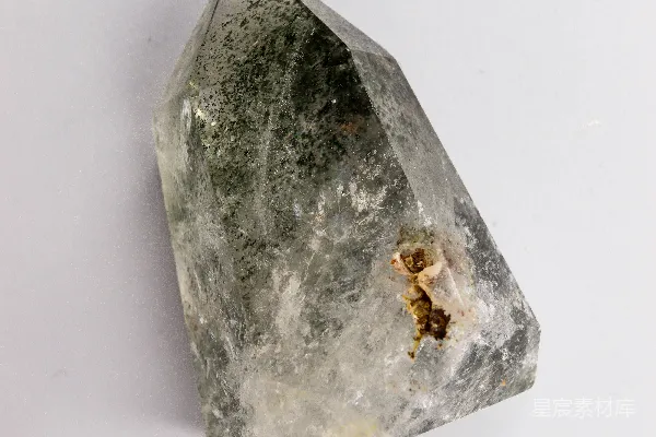 高清摄影 一颗清澈的水晶，其中含有绿色和棕色的杂质。