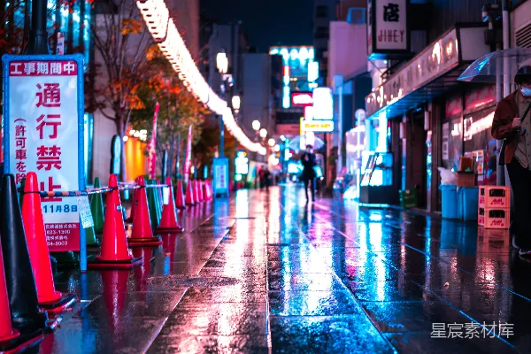 高清摄影 夜晚湿漉漉的城市街道上，有交通锥。