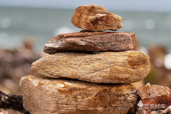 高清摄影 沙滩上的一堆石头，背景是海洋。